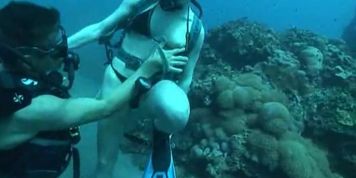 Snorkeling couple lick and screw underwater with scuba masks and scuba gear public sea underwater