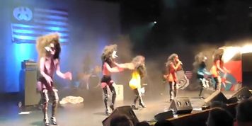 Painted tits bounce around on the stage at a rock concert