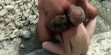 Voyeur hidden in the top of the cliff secretly film nudist couple