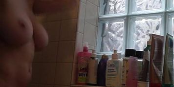 Superbe femme mature aux seins naturels est filmee nue sous la douche