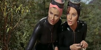 Two hot women in vintage rubber wetsuits and swimcaps (moviescene)