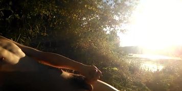 Natural teen boy lays nude by the river, wanks his hairy cock, squirts cum and relaxes during summer