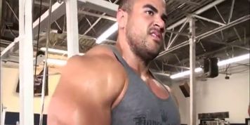 Sexy sweaty bodybuilder flexing biceps with hairy armpits