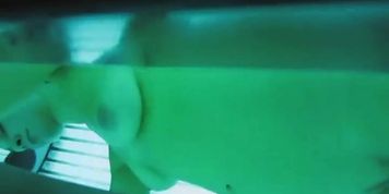 Voyeur spied on a naked sexy woman in the tanning machine at a solarium