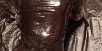 Master sliding on a tight rubber pup hood with inflatable dildo gag before fuck machine training