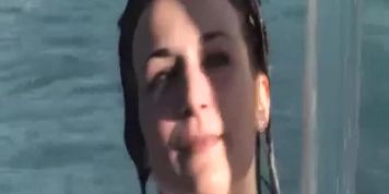 cute girl swims in white shirt at public pool