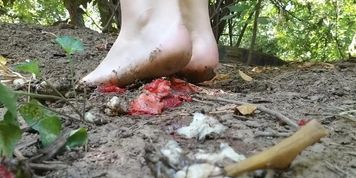 Barefooted fruit crush girl tramples banana and strawberries