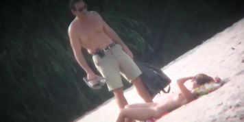 Spy cam shot of a hot nudist blond tanning on the beach