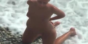 Girl with plug in the ass poses for a guy at public beach