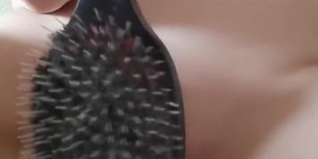 Naked shaved pussy is spanked with big hairbrush 