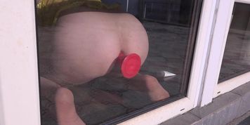Anal orgasm by the window. Busty girl with a dildo fucks ass Doggystyle.