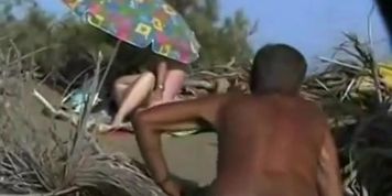 Middle aged couple having oral sex on the beach