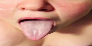 Girl holds out her long tongue for you covered in spit