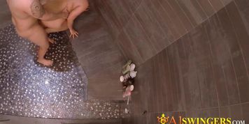 This swinger couple is having a pleasant moment while having a shower