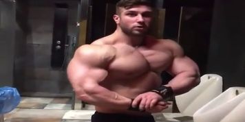 hot bodybuilder hunk is flexing in toilet