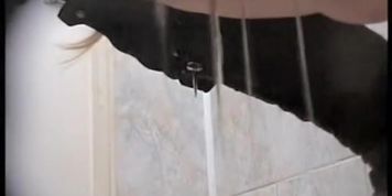 Amateur in high boots sits pissing in public toilet