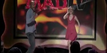 Live TV show with a black dude and a blonde with jiggling boobs