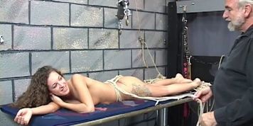 Long haired brunette gets bound face down to table
