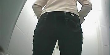 Girl in black jeans pants pissing in toilet