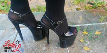 Lady L walking glas road with xtreme high heels.