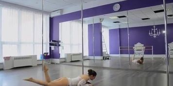 La gymnaste s'entraine grace une barre de pole dance