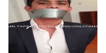 Handsome Brazilian slave in suit, tied up and tape gagged