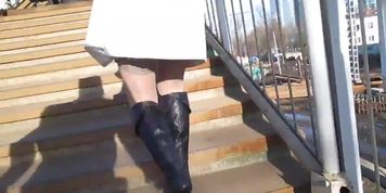 Girl in black leather boots and tan stockings going upstairs