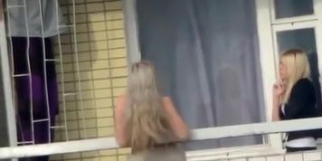 Voyeur films topless chick in the balcony