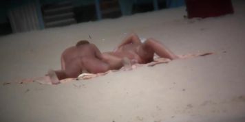 Couple exposing for the hidden cams at the beach