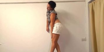 The girl is dancing on the table in the office. Striptease for the boss.