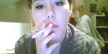 Short hair brunette smoking with nose exhales and dangling