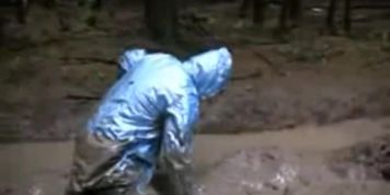 BBW cougar rolls in mud wearing a pvc raincoat