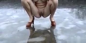Russian beauty in heels peeing on frozen lake