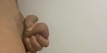 Uncircumcised dick and big eggs are mastrubated near the white wall