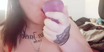 Goth slut sucking on a dildo 