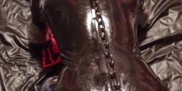 Chained to the bondage post, rubber gimp pup slave getting relentlessly fucked by the screw machine (Alison Webb)