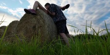 Des naturistes copulent nus sur une botte de foin au coucher du soleil