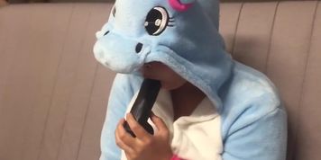 Girl in unicorn onesie gagging on dildo